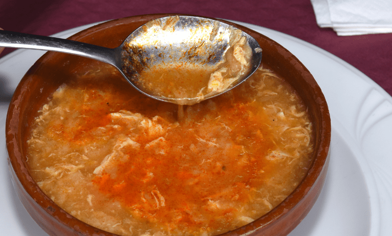 Sumérgete en un remolino de aromas tentadores con nuestra irresistible sopa de ajo y pan castellana. En esta exquisita imagen, capturamos la esencia misma de la tradición culinaria española, con un plato rebosante de sabores reconfortantes y texturas reconfortantes. Desde el dorado del pan crujiente hasta el aroma embriagador del ajo dorado en aceite de oliva, cada detalle de esta deliciosa sopa invita a tus sentidos a un viaje de placer gastronómico. Con un toque final de perejil fresco picado y un chorrito de aceite de oliva virgen extra, esta imagen te transportará instantáneamente a la mesa de un hogar español, donde la comida es más que sustento: es una celebración de la vida y la cultura. Déjate tentar por esta invitación visual a un festín de sabor y tradición. ¡Bienvenido a un mundo donde cada cucharada es un regalo para el alma!