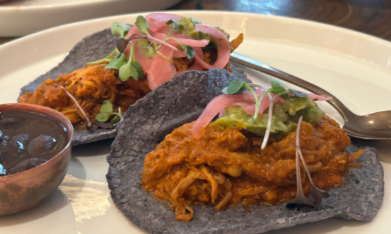 Disfruta de la explosión de sabores de la cochinita pibil en Bakan Madrid: tierno cerdo ibérico en achiote y zumo de naranja, con guarniciones tradicionales y tortillas caseras calientes.